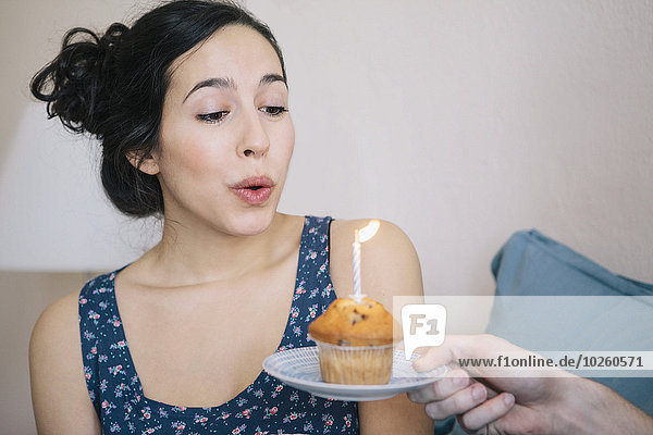 Interior,zu Hause,junge Frau,junge Frauen,Mann,halten,Kerze,Kerzen ausblasen,cupcake