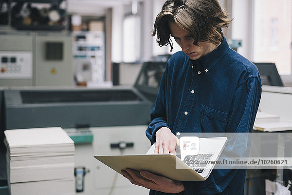benutzen,Notebook,Technischer Beruf,jung,Fabrikgebäude