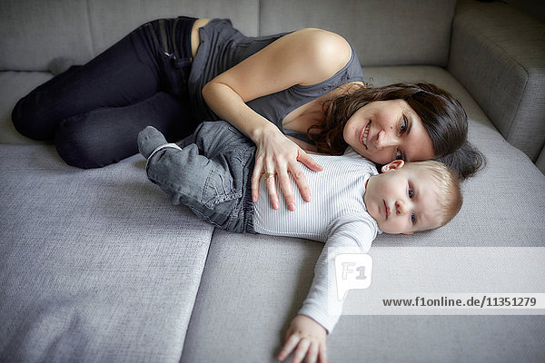 Mutter und Baby liegen auf der Couch