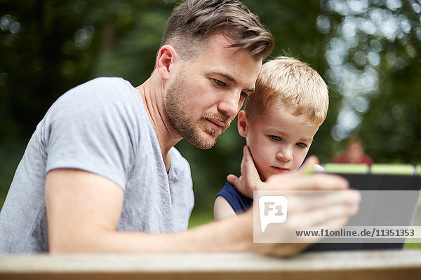 Vater und Sohn schauen auf Tablet