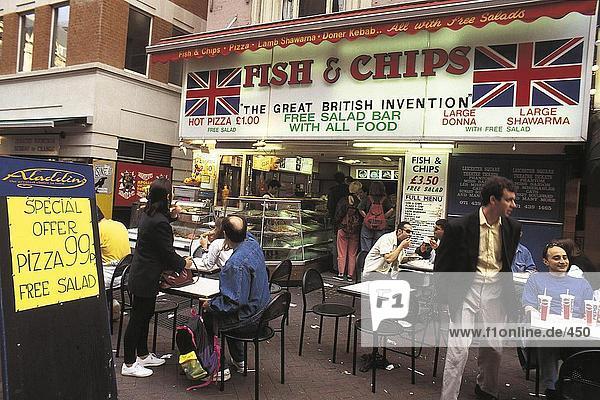 Menschen sitzen und Essen außerhalb ein Fisch und Chips Shop  London  Großbritannien  Europa