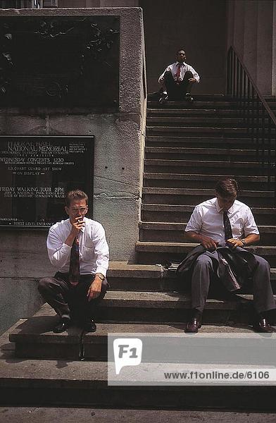 Drei Geschäftsmänner sitzen auf Stufen des federal Hall  New York City  New York State  USA