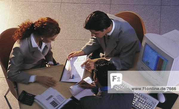 High angle view of three businesspeople discussing in a meeting