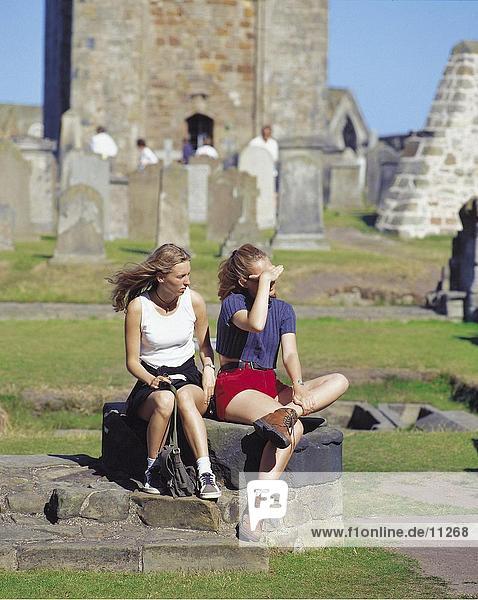Weibliche Touristen sitzen an Ausgrabungen Website  Ruine der Kathedrale von St. Andrews  St. Andrews  Schottland