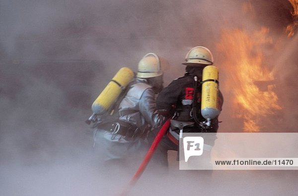 Feuerwehrleute hinausbringend flames