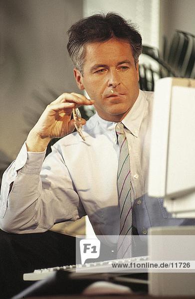 Businessman brooding in front of a computer