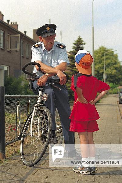 Polizist auf Fahrrad und Gespräch mit Mädchen  Niederlande