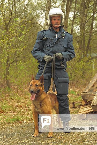 Policeman in protective clothing and holding dog on leash  Netherlands  Europe