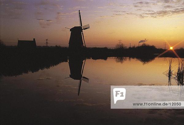 Silhouette der traditionellen Windmühle bei Sonnenuntergang  Niederlande