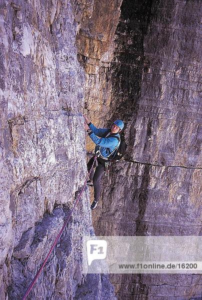 Male mountain climber scaling a rock face  Dolomites  Italy