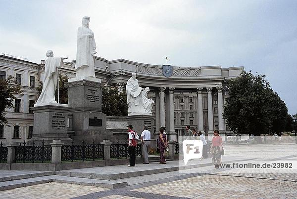 Touristen stehen in der Nähe von Statuen an Parlamentsgebäude  Kiew  Ukraine