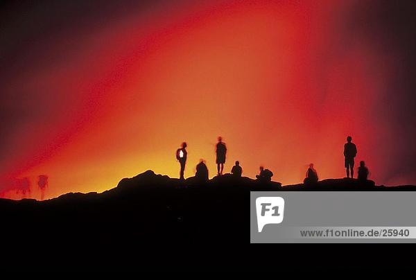 Silhouette der Wanderer auf Berg bei Sonnenuntergang  Kilauea-Vulkan  Hawaii Volcanoes Nationalpark  Big Island  Hawaii  USA