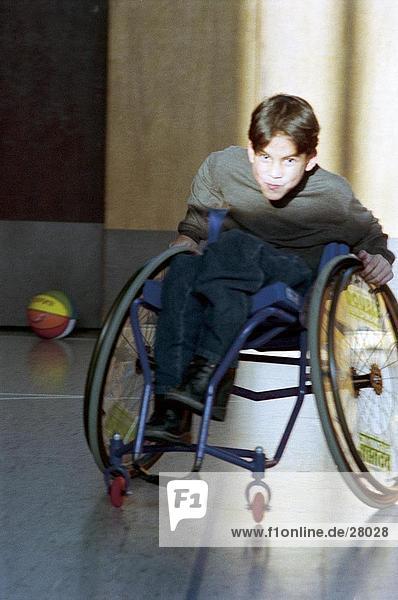 Handicapped Junge spielt in Rollstuhl