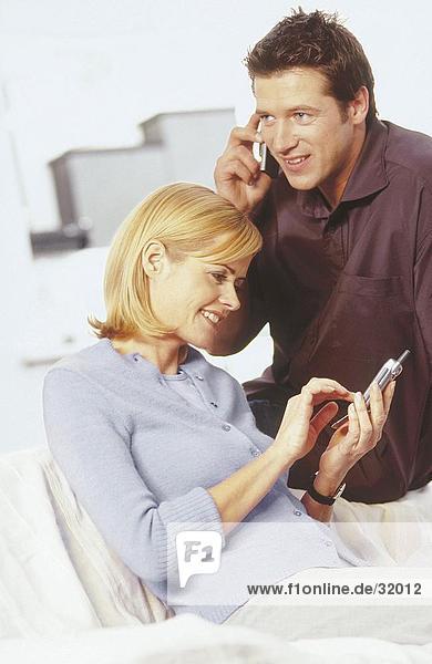 Young couple using mobile phones