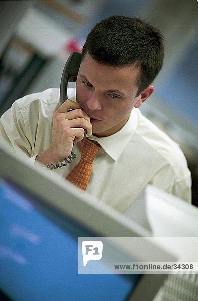 Kaufmann sprechen auf ein Festnetz-Telefon in einem Büro