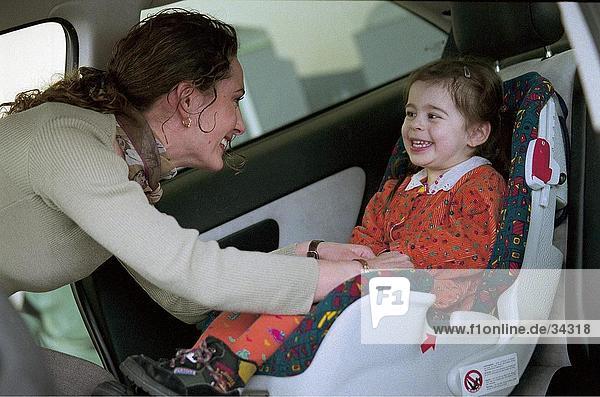 Side profile of a woman playing with her daughter in a car