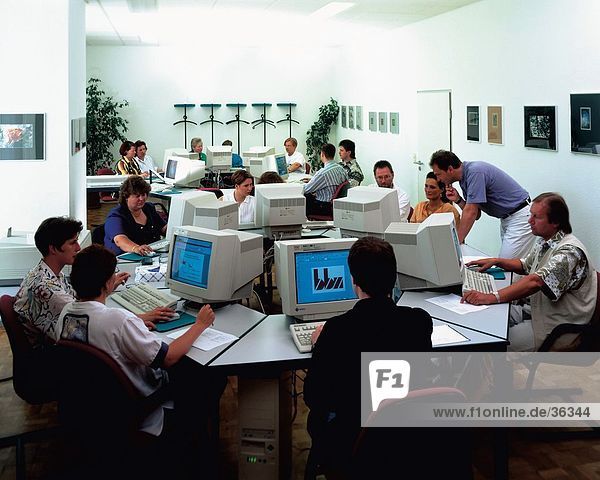 Gruppe von Menschen auf einem Computer in einer Schule