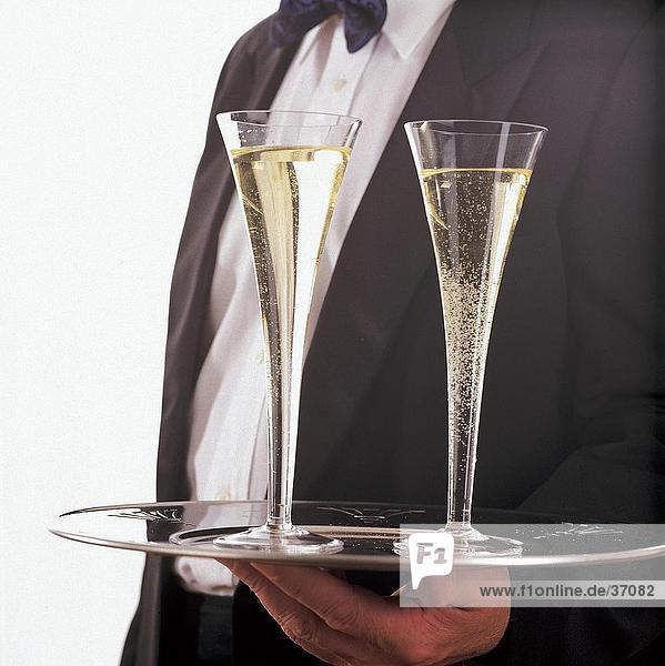 Nahaufnahme der Champagner-Gläser auf einem Tablett in einer Hand Kellner