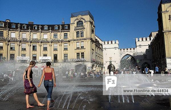 Menschen genießen in der Nähe von Brunnen in der Stadt Platz  Karlsplatz  München  Bayern  Deutschland