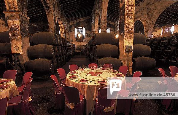 Place setting inside cellar with wine casks  El Puerto de Santa Maria  Cadiz  Andalusia  Spain