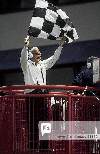 Mann waving Karierte Flagge in Autorennen