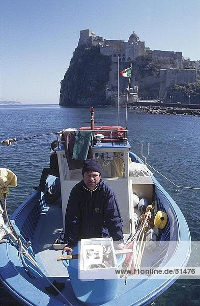 Fisherman on boat in front of castle  Aragonese Castle  Ischia  Italy