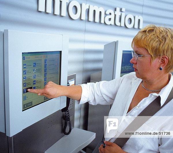 Frau mit Touch Screen Informationsmaschine