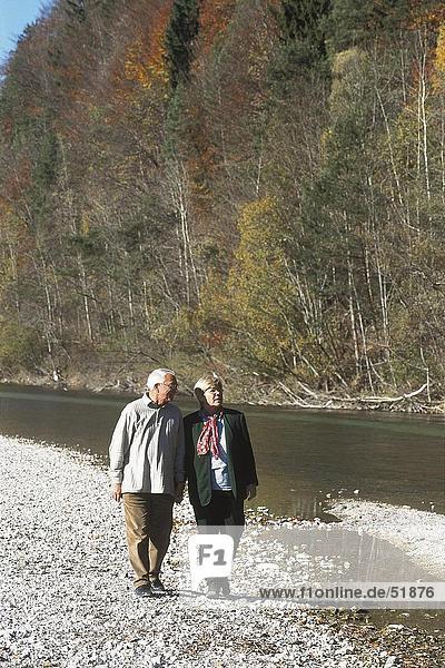 Senior couple walking near river