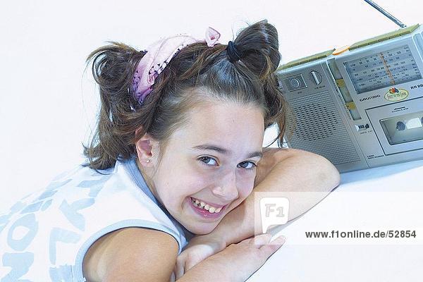 Teenagerin liegend mit Radio und lächelnd portrait