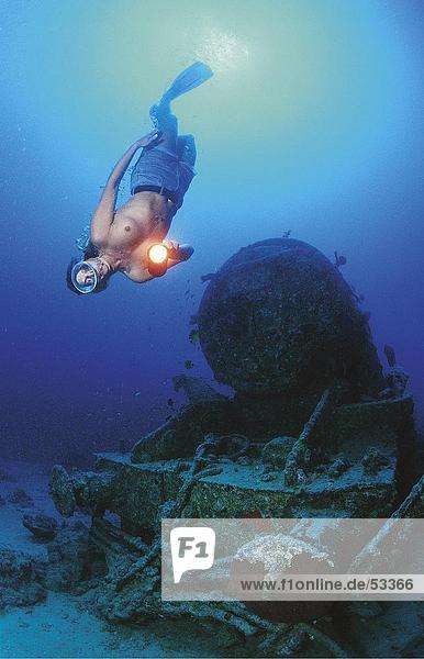 Scuba Diver Blinklicht auf Schiffbruch der Engine Unterwasseraufnahme  Ägypten