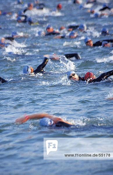 Crowd of triathletics swimming in water for triathlon