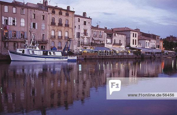 Buildings at waterfront reflected in river  Orb River  Agde  Herault  France