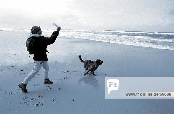 Seitenansicht Frau mit ihrem Hund am Strand