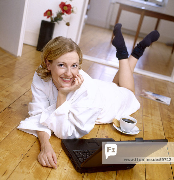 Woman lying on floor and using laptop  elevated view