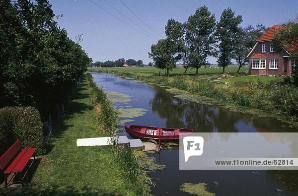Boat moored in canal  Wynhamster Kolk  Dollart  East Frisia  Lower Saxony  Germany