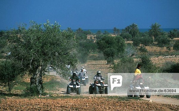 Quad bikers racing on dirt road Djerba Tunisia