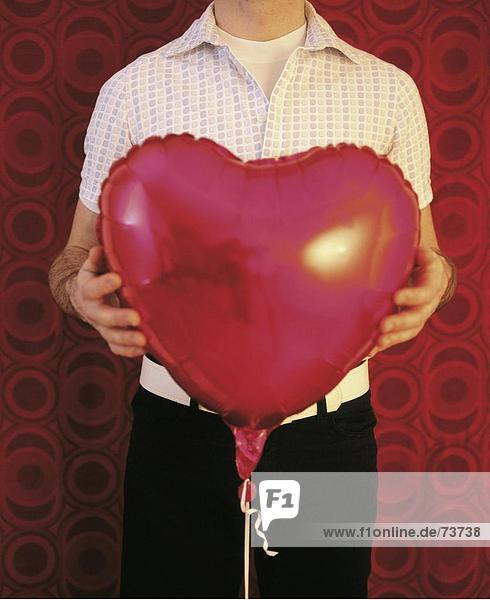 10542760  Ballon  halten  Herzen  Herzform  Körper-Detail  Liebe  Luft Ballon  Mann  rot  Symbol