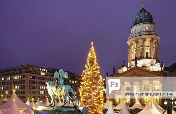 Weihnachtsmarkt vor beleuchtet Kirche in der Dämmerung  Gendarmenmarkt  Berlin  Deutschland