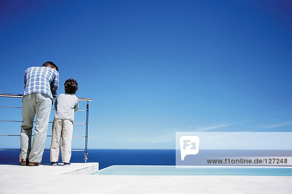 Vater und Sohn genießen den Blick aufs Meer