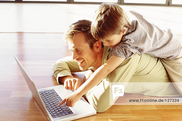 Vater und Sohn spielen mit einem Laptop