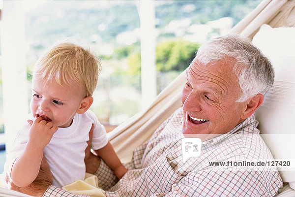 Grandad with grandson in a hammock