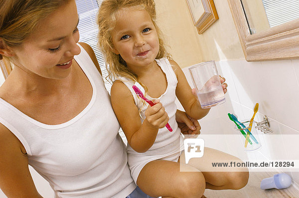 Mutter hilft Tochter beim Zähneputzen