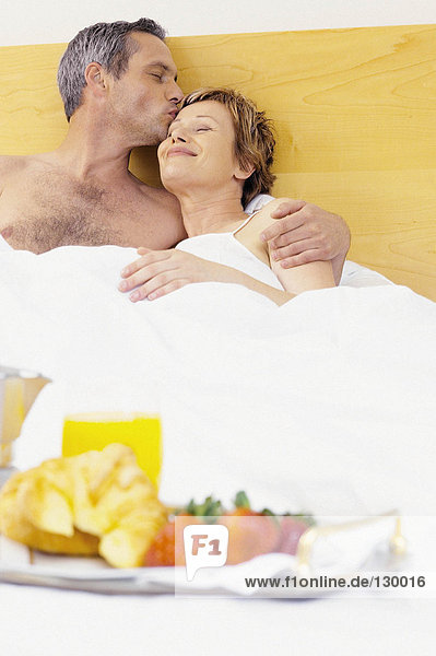 Mann und Frau beim Frühstück im Bett