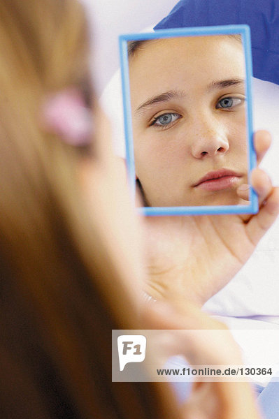 Teenager Mädchen schaut in den Spiegel