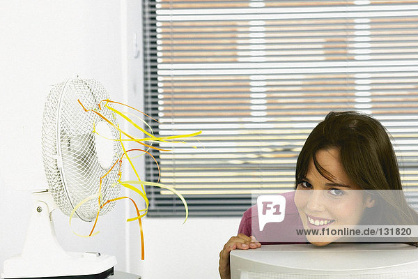 Geschäftsfrau gekühlt durch Ventilator im Büro