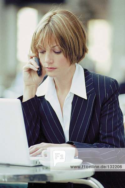 Businesswoman with laptop and cellphone at a cafe