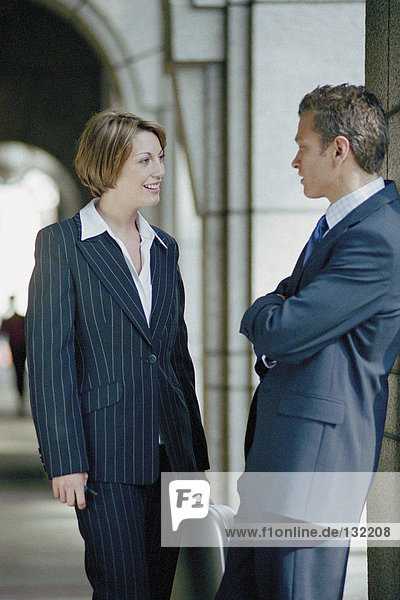 Businessman and businesswoman talking outside office