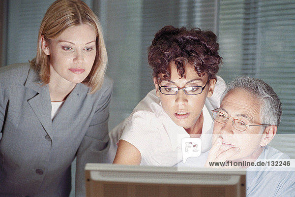 Businesspeople looking at computer screen