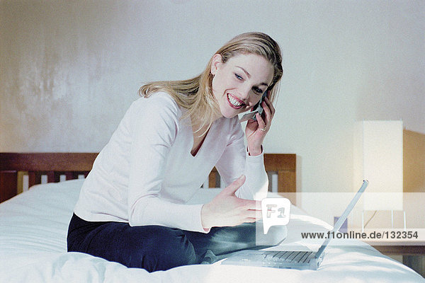 Frau im Schlafzimmer mit Laptop