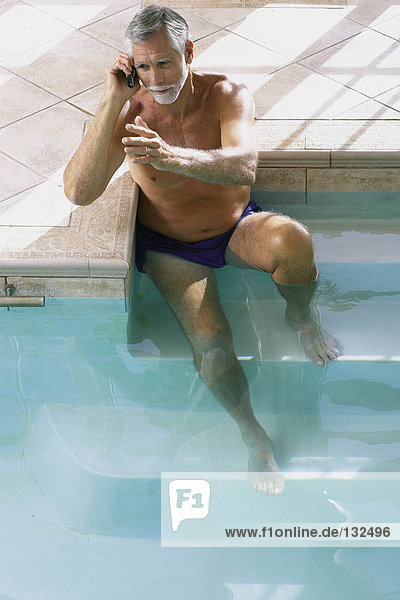 Mann im Schwimmbad mit Handy